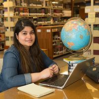 Student works on her laptop in the library.